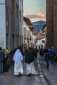 Two nuns walking down a small street in the historic district of Cuzco, Peru
