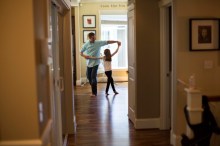 father dances with his daughter in their home